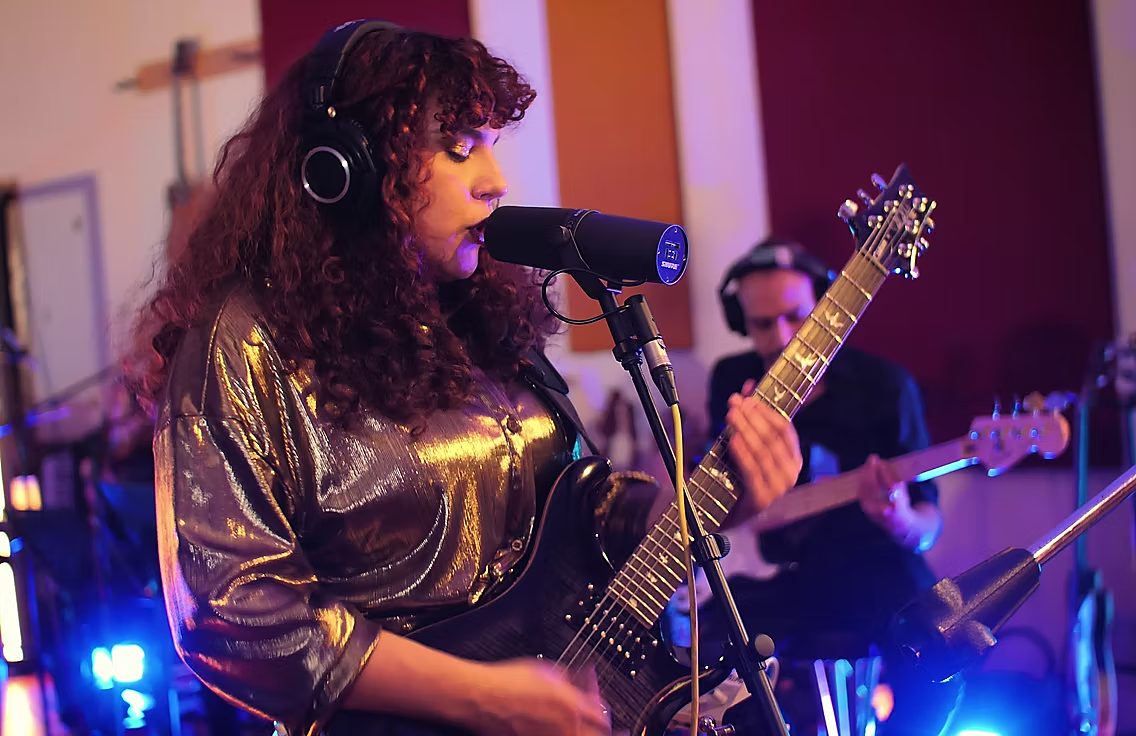 Singer playing guitar at the microphone